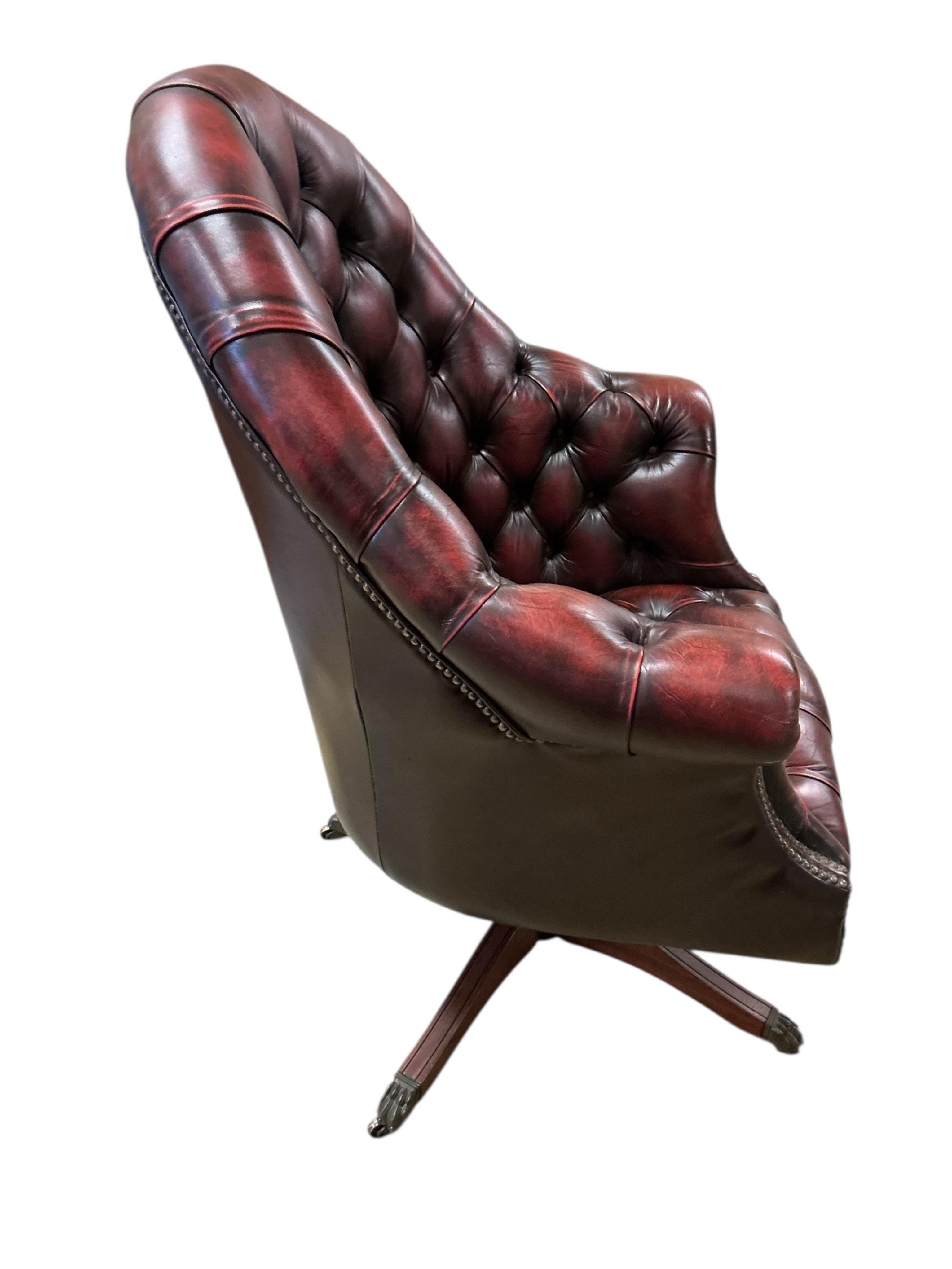 A reproduction buttoned burgundy leather swivel desk chair, width 80cm, depth 70cm, height 110cm
